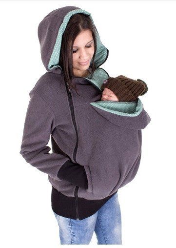 a woman is wearing a hoodie and holding a mitt