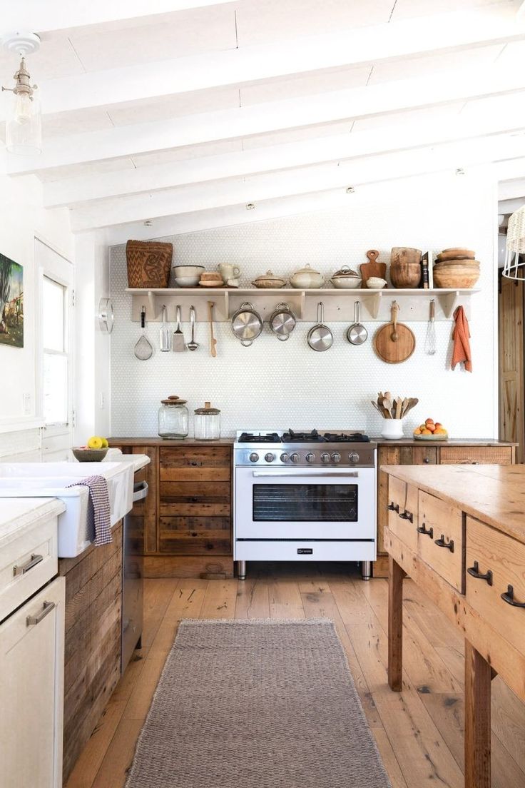 a white stove top oven sitting inside of a kitchen next to wooden cabinets and drawers