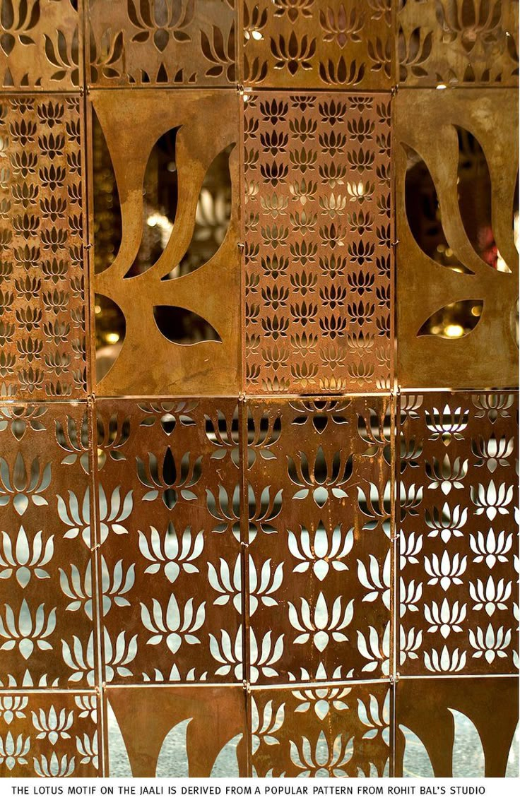 an intricately designed metal screen with cutouts and leaves on it's sides