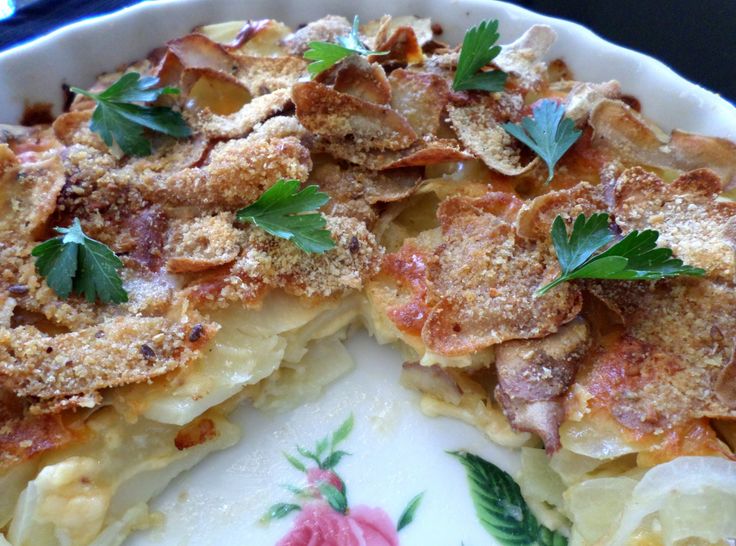 a close up of a pie on a plate with leaves and flowers around the crust