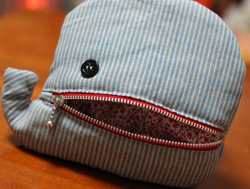 a stuffed whale toy sitting on top of a wooden table