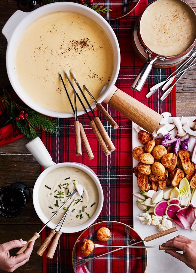 a table topped with bowls of soup and plates of food next to utensils