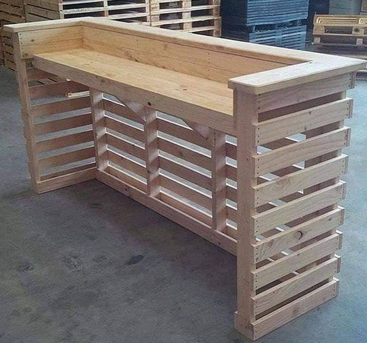 a bench made out of wooden pallets in a warehouse