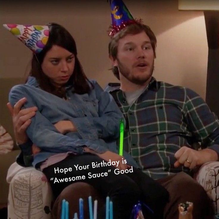 a man sitting next to a woman on top of a couch in a room filled with candles