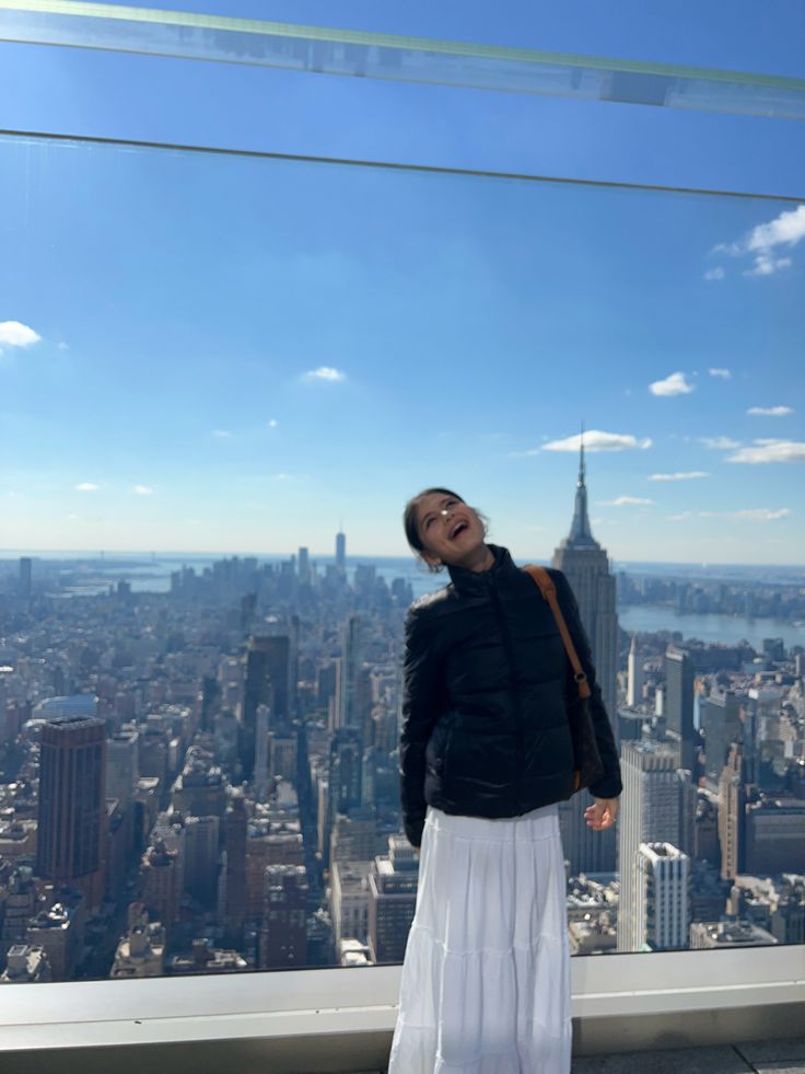 a woman standing on top of a tall building