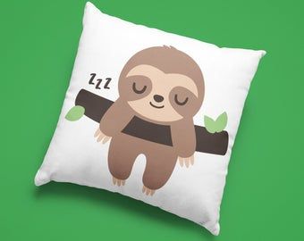 a white pillow with a cartoon slotty hanging from a tree branch on green background