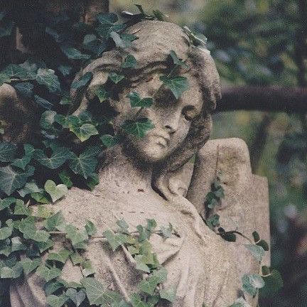 a statue with ivy growing over it's head