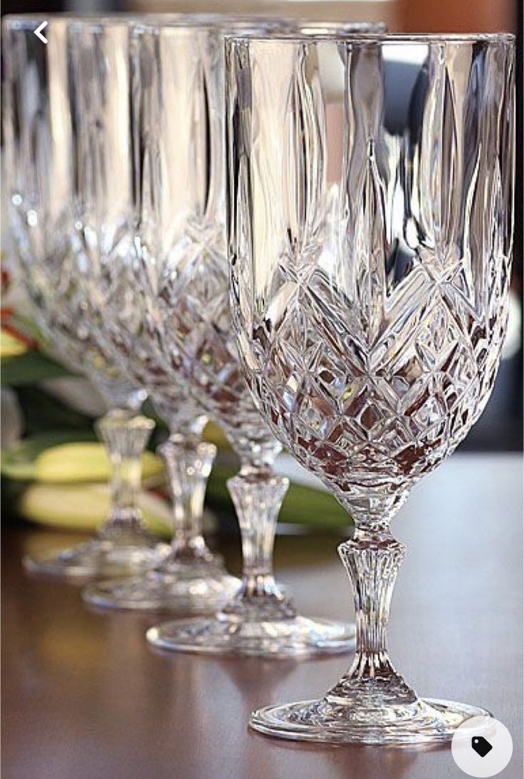 three wine glasses sitting on top of a wooden table