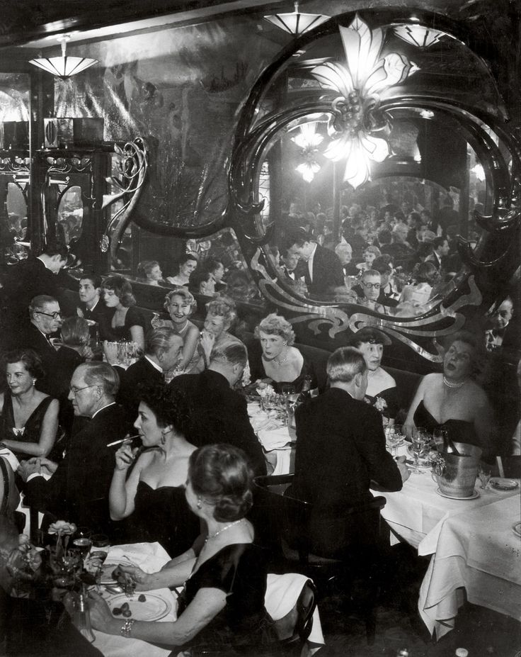 black and white photograph of people sitting at tables