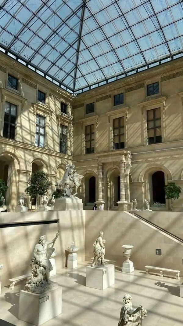 the inside of a building with statues and glass roofing on it's sides