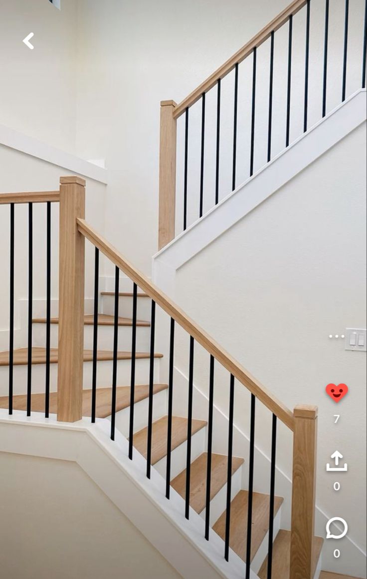 the stairs are made of wood and have black railings on each handrail, along with a red heart