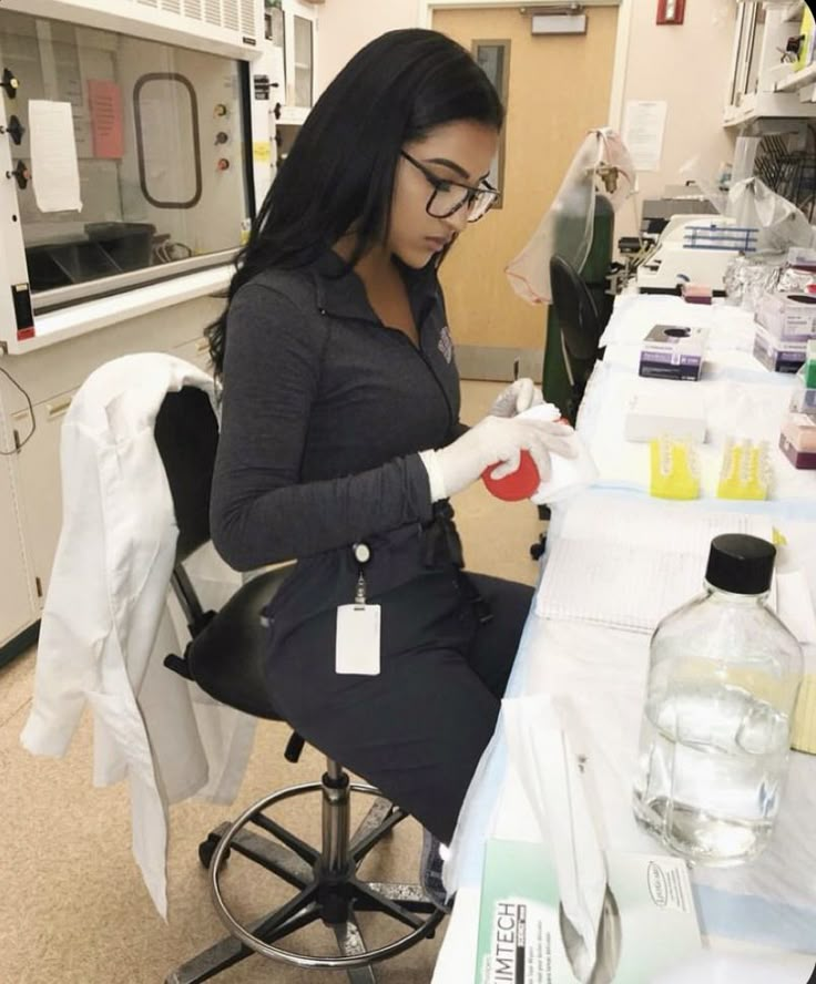 a woman sitting at a table in a lab