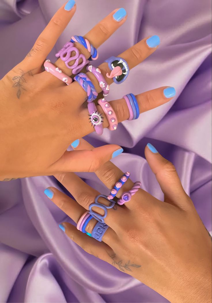 two hands with manicured nails and rings on them