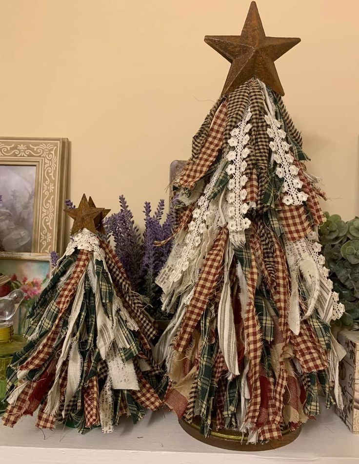 a christmas tree made out of fabric and other items on a mantle with pictures in the background