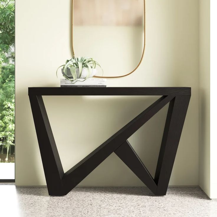 a modern console table with a mirror and plant on it in front of a window