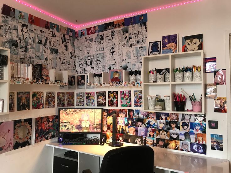 a desk with a computer on top of it in front of a wall full of comic books