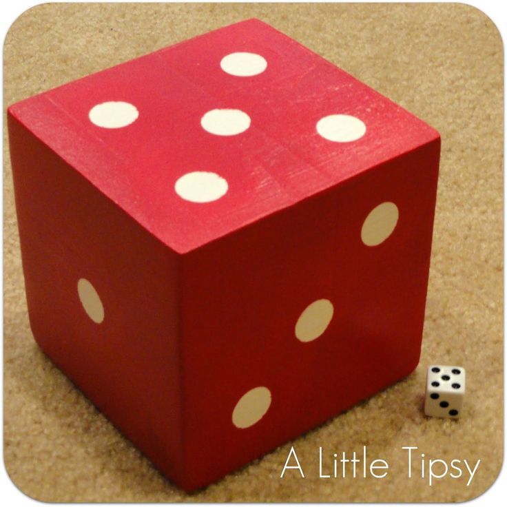 a red dice with white dots sitting on the floor