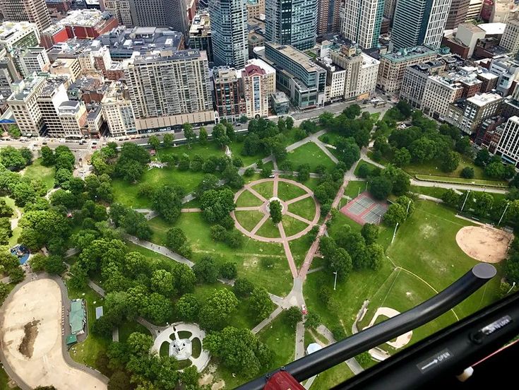 an aerial view of a park in the middle of a large city with tall buildings