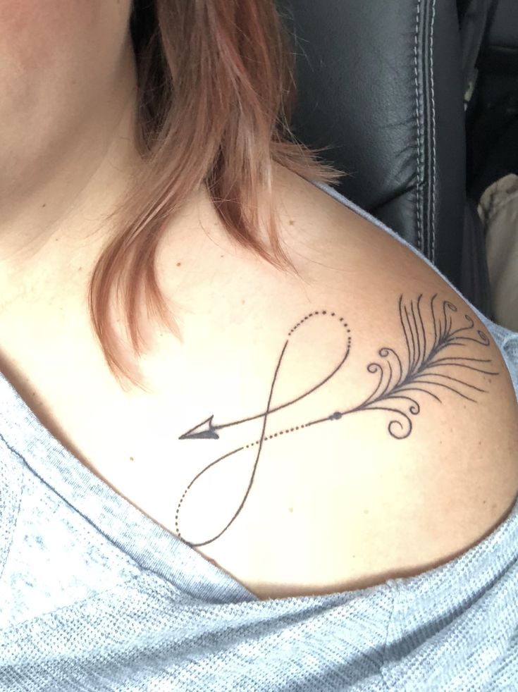 a woman with a tattoo on her chest and an arrow in the middle of it