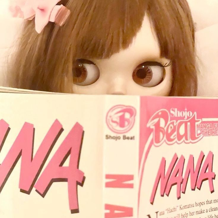 a doll is holding up a book with the word mama on it's face