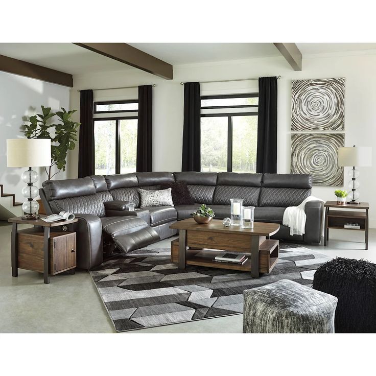 a living room filled with lots of furniture and large windows in the wall behind it