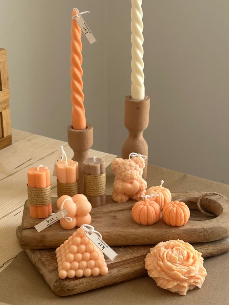 a wooden tray with candles and pumpkins sitting on it's side next to other decorative items