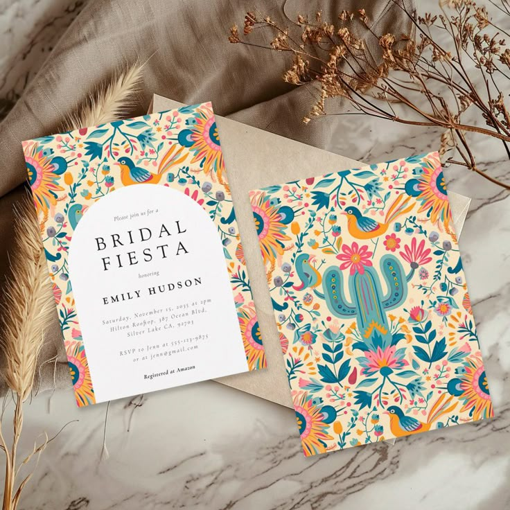 a wedding card with an ornate design on the front and back, next to some dried plants