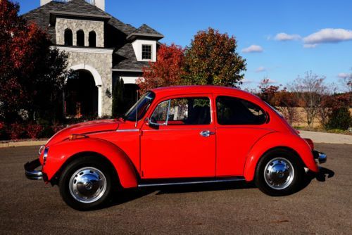 an old red car parked in front of a house