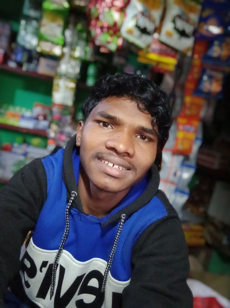 a young man sitting in front of a store