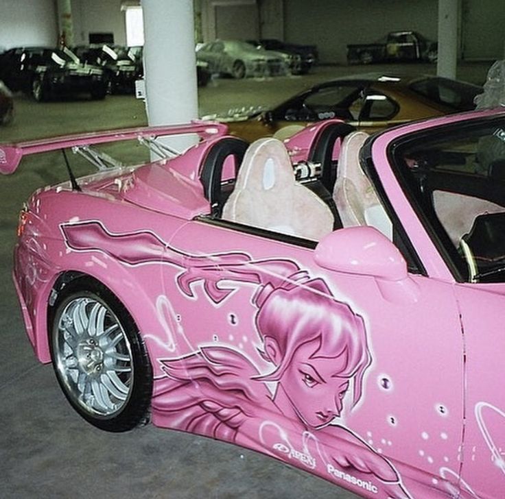 a pink sports car painted with an image of a woman