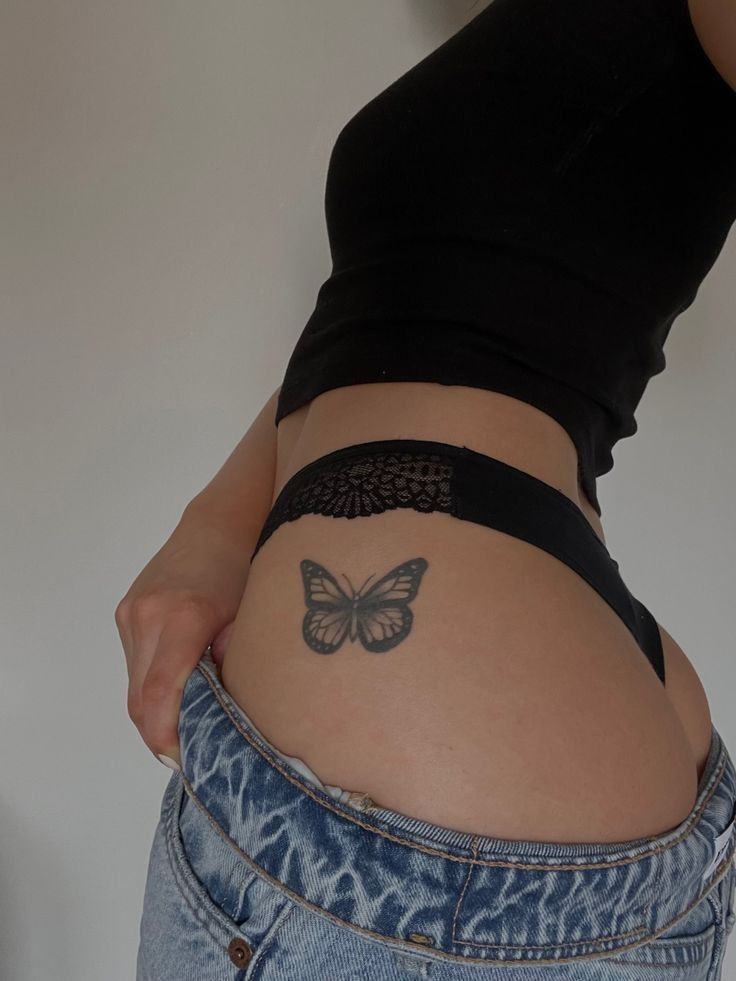 a woman's stomach with a butterfly tattoo on her lower body and bottom part