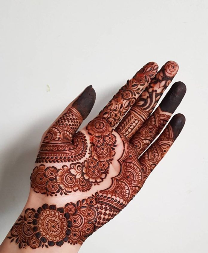 a hand with henna tattoos on it