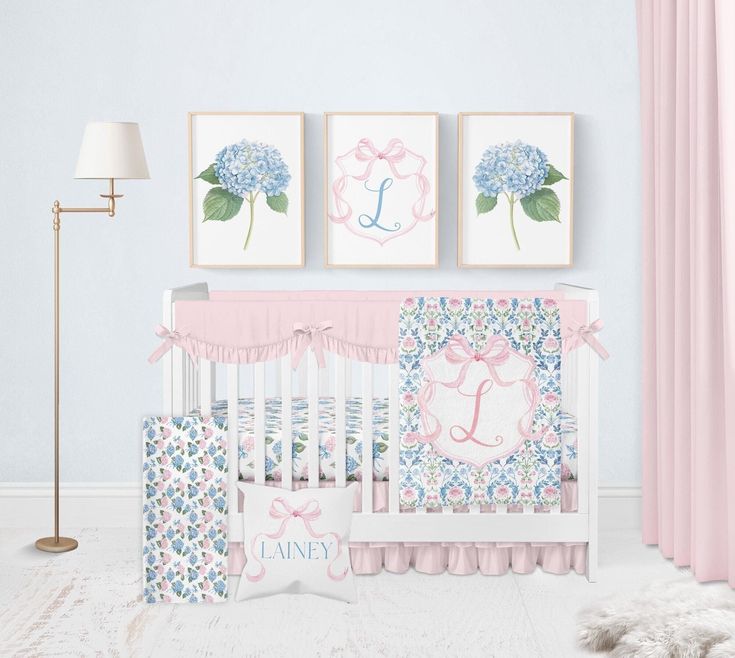 a baby's room with pink, blue and white decor on the wall next to a crib