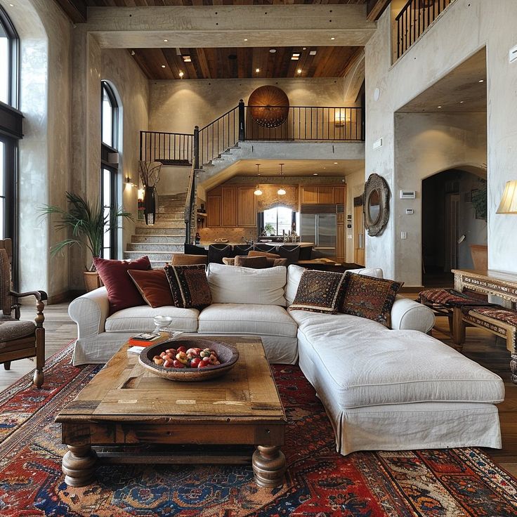 a living room filled with lots of furniture next to a fire place and staircase leading up to the second floor