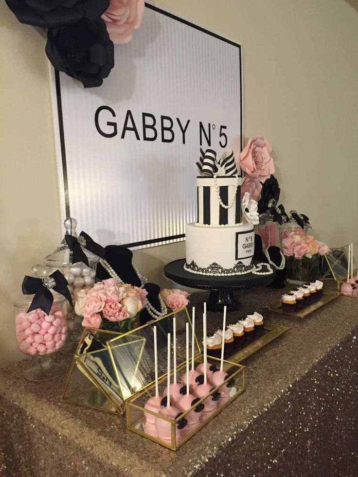 a table topped with cake and cupcakes next to a sign that says gabby n's