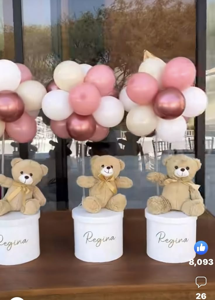 three teddy bears sitting on top of two white buckets with pink and white balloons