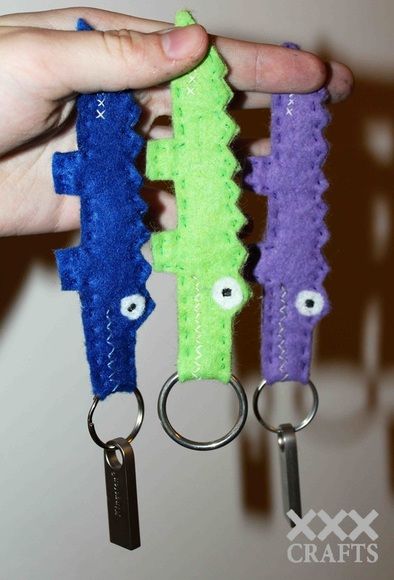 someone is holding two keychains made to look like monsters