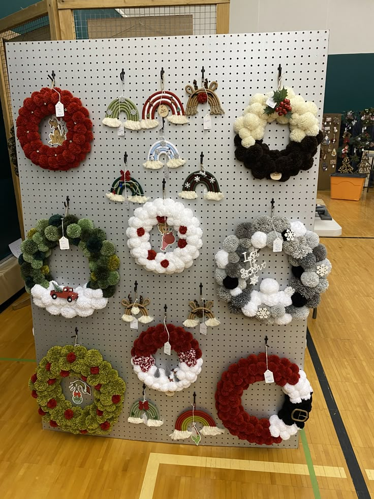 there are many wreaths hanging on the pegboard in this room and it looks like they have been made out of yarn