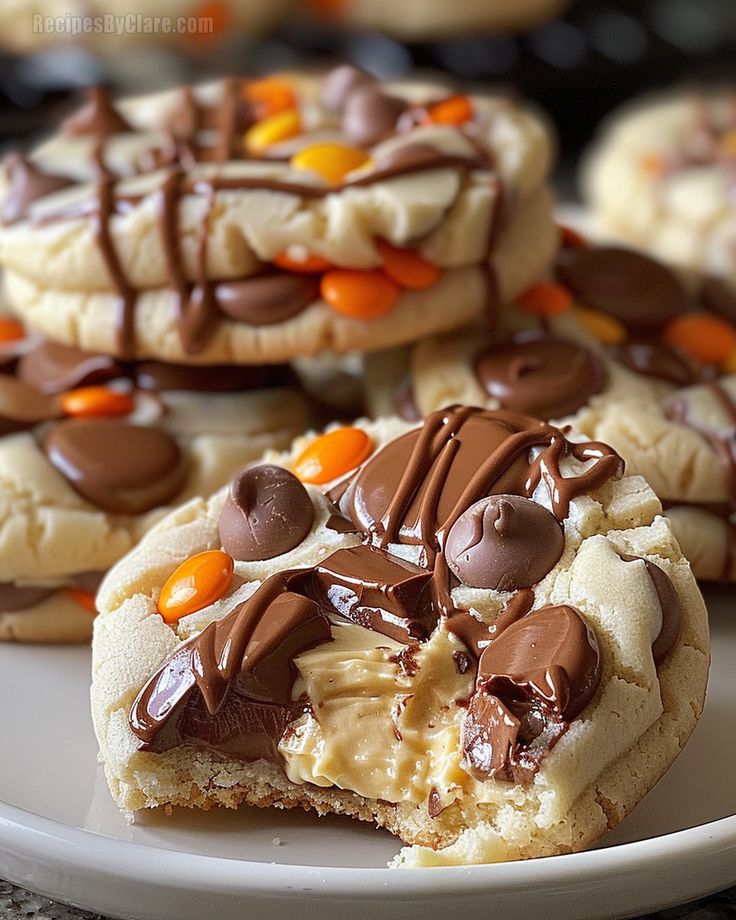 several cookies with chocolate and candy on top are arranged on a white plate, ready to be eaten