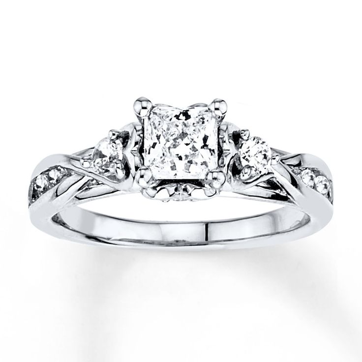 an engagement ring with three stone diamonds on the shoulders and side stones in the band