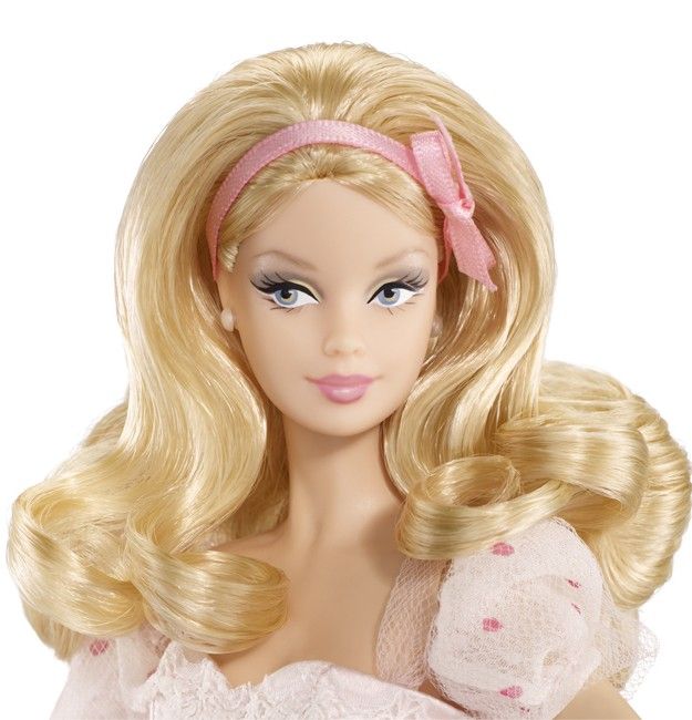 a barbie doll with blonde hair wearing a pink dress and bow in front of white background