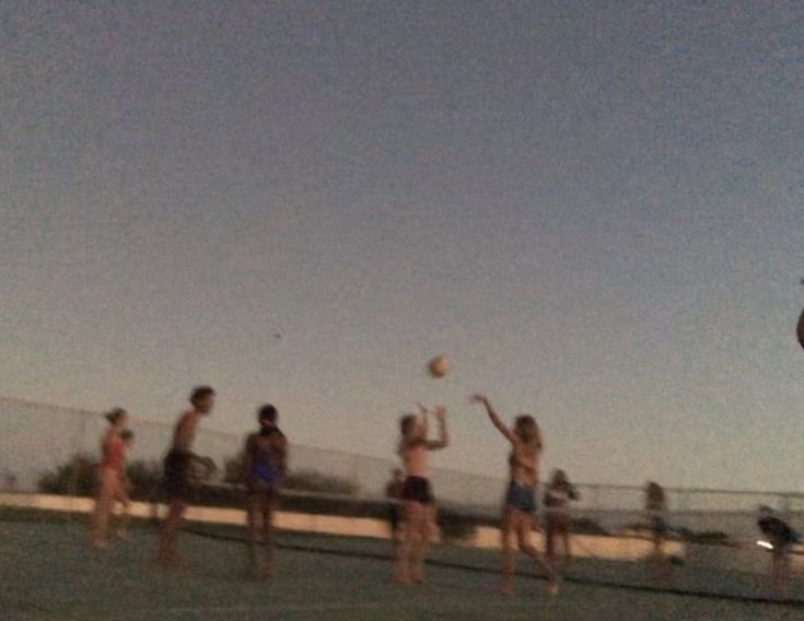 a group of people standing on top of a tennis court