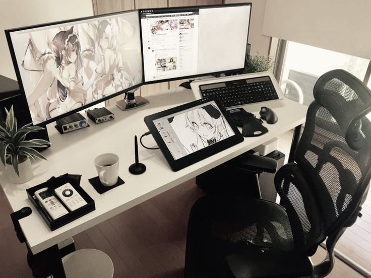 a computer desk with two monitors and a tablet