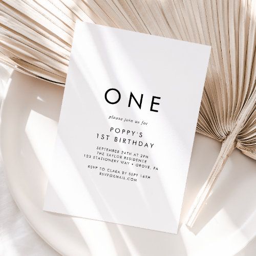 a white plate topped with a piece of paper next to an open book and palm leaf