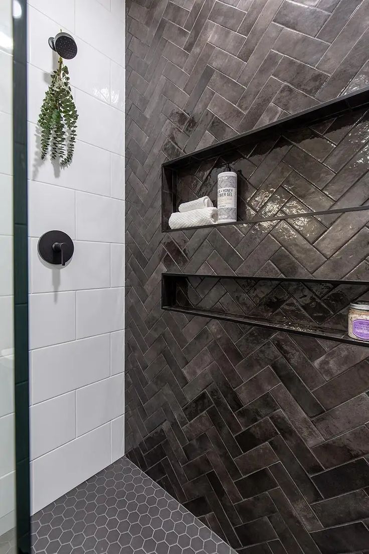 a walk in shower sitting next to a tiled wall