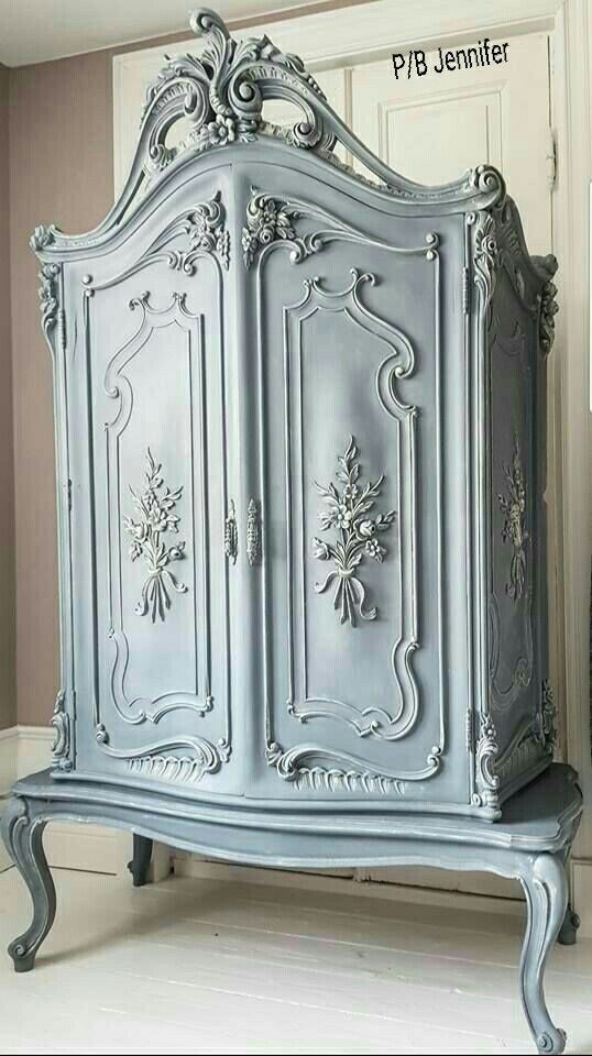 an ornately painted armoire in a room