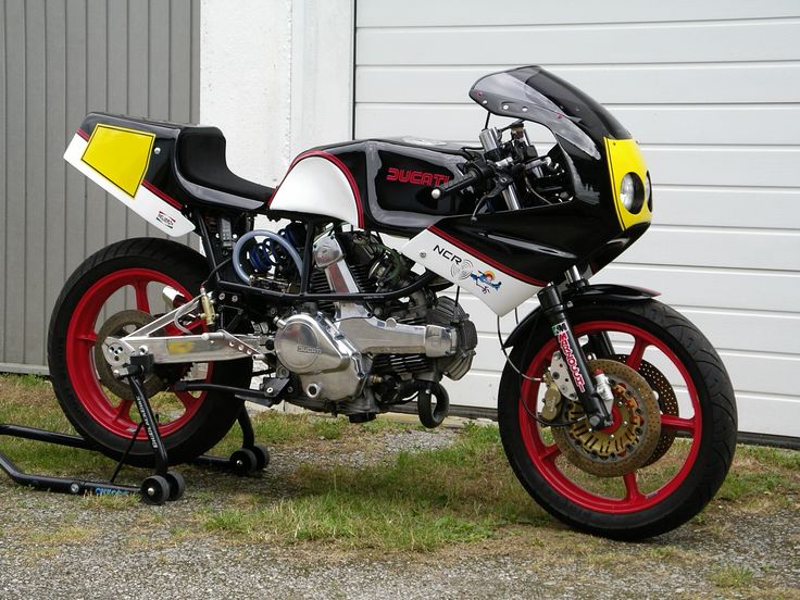 a motorcycle parked in front of a building with red and yellow rims on it