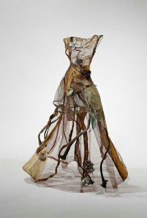 a dress made out of mesh with flowers and leaves on the bottom, sitting in front of a white background