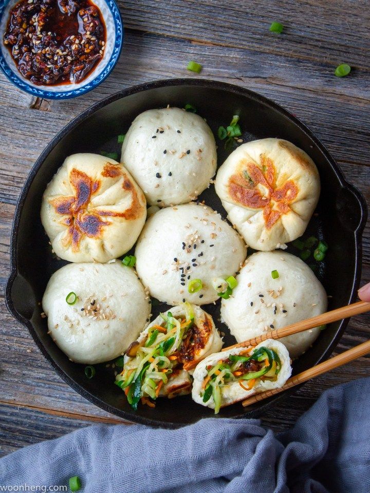 a pan filled with dumplings and chopsticks on top of a wooden table