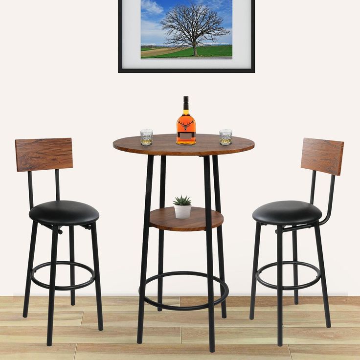 two stools and a table with a bottle on it in front of a painting